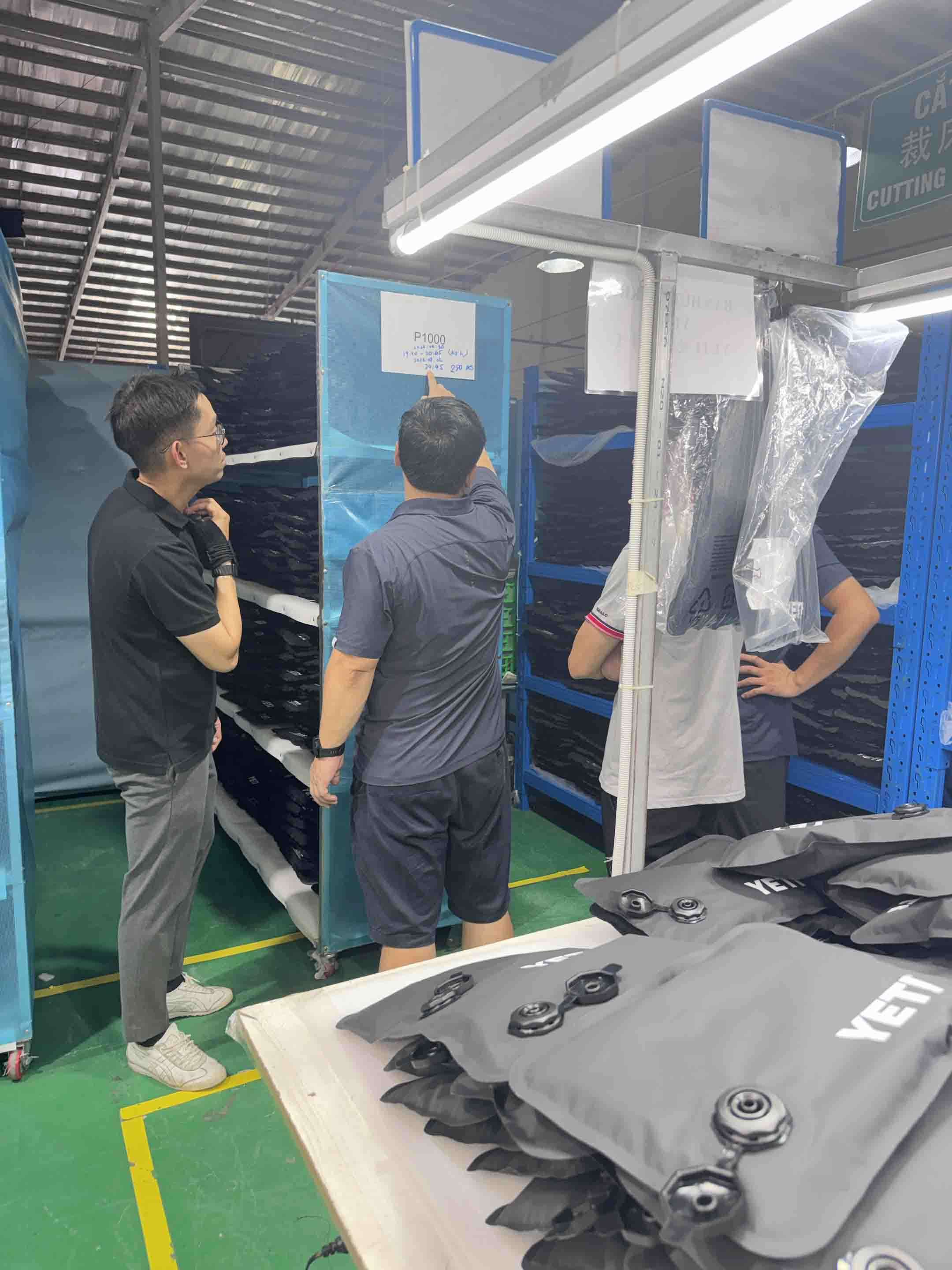 Sealock and YETI teams reviewing the P1000 batch production record beside finished YETI soft cooler bags